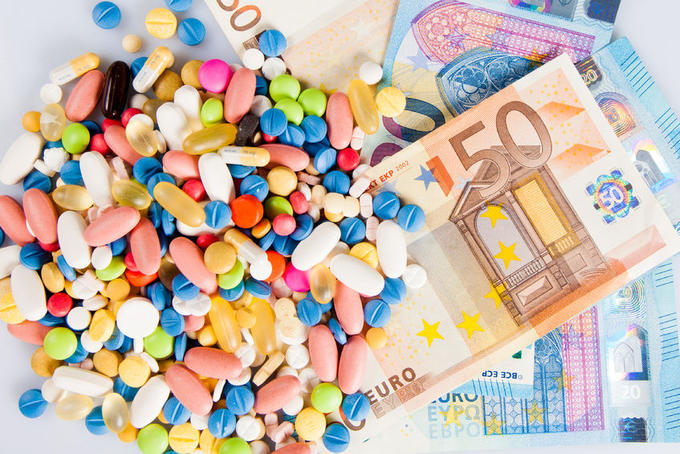 56856851 - pills of different colors on money